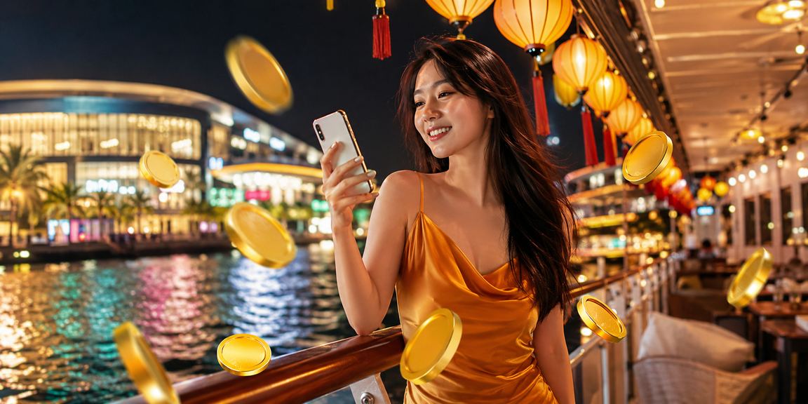 Khu chợ đêm Phú Quốc về ban đêm, cảnh người dùng kiểm tra cashback và thưởng trên điện thoại